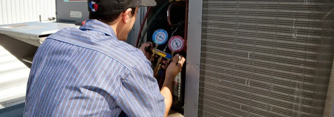 HVAC technician servicing a condenser unit in Gainesville